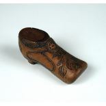 A treen shoe snuff box dated 1637, the lid sliding off behind a carved rosette clasp to the shoe's