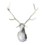 A matched pair of composition stone and antler stag's heads, the Queen Anne style stone heads