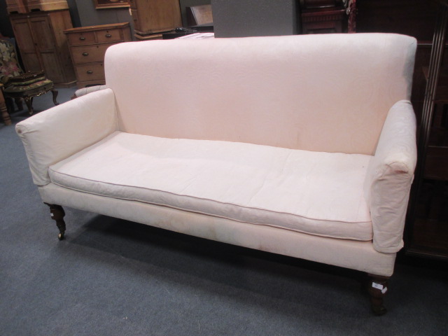 A white settee on brass caster feet