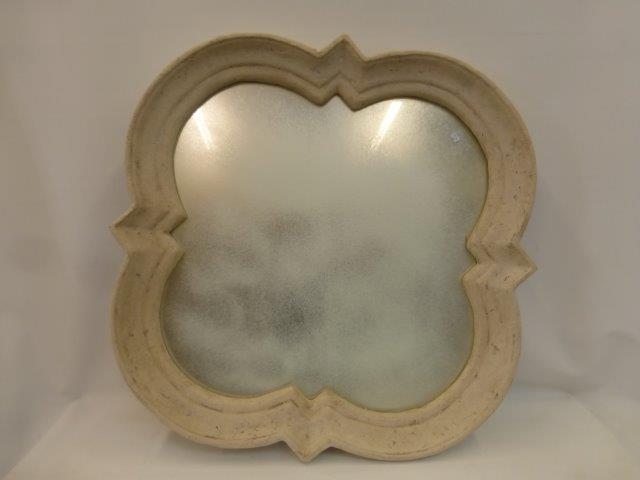 A large contemporary shaped wall mirror with plaster on a metal frame.