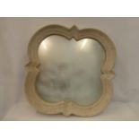 A large contemporary shaped wall mirror with plaster on a metal frame.