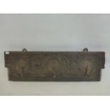 A 17th Century carved wooden plaque with three iron coat hooks.