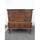 A George I oak chest on stand of two short and two graduated long drawers, with veneered walnut