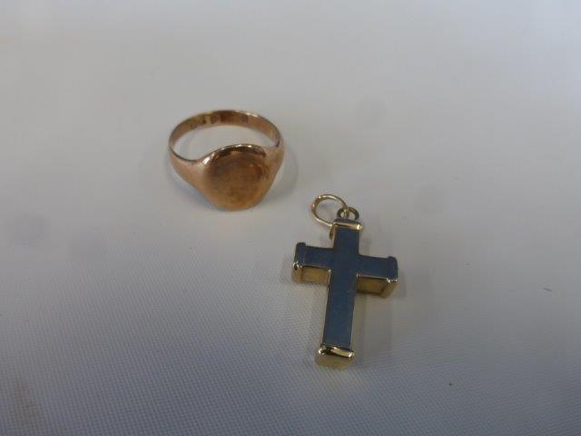 A 9ct gold crucifix and a 9ct rose gold signet ring.