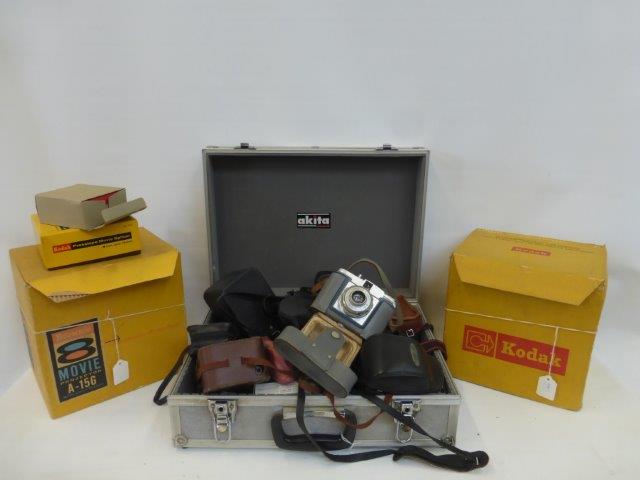 A collection of assorted cameras, also two Kodak movie projectors, a camera suitcase, and a Bilora