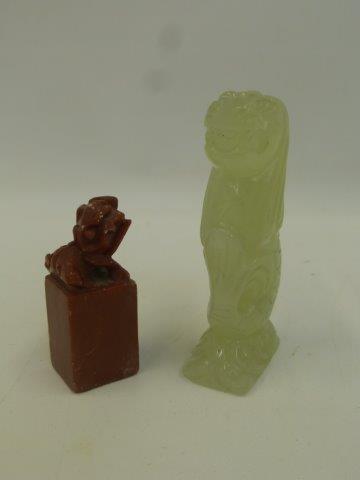 A carved jade figure of a mythical lion fish and a carved soapstone dog of foe.