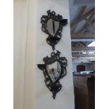 A pair of early 20th century left and right ebonised mirror backed candle wall sconces with