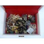 A box of assorted beads, costume jewellery, a butterfly brooch etc.