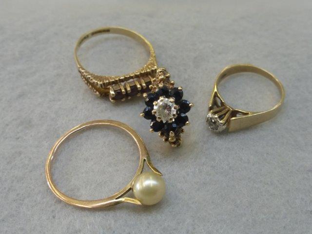 Four assorted 9ct gold rings set with sapphires, garnets, diamonds etc.