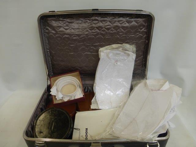 A suitcase with an assortment of gentlemen's stiff/wing collars, collar boxes, dress shirts, shirt