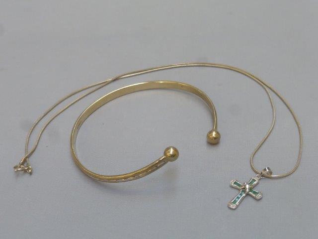 A 9ct gold bangle and a Brooks & Bentley "The Eternal Love" emerald and diamond cross.