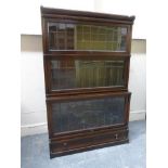 An oak lead glazed Globe Wernicke three tiered book case with single drawer base.