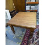 A 19th Century pine extending dining table with two extra leaves contained within a dummy drawer,