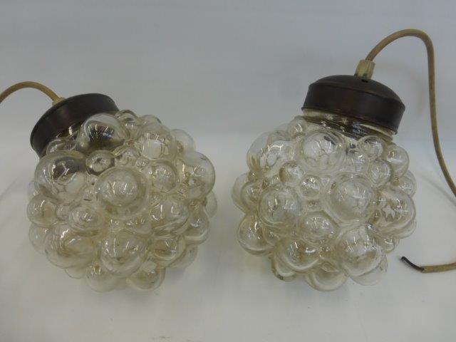 A pair of ceiling lights with clear bublle effect shades.