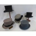 Five top hats including a pop-up example by Horne Bros. Ltd. of Oxford St., a Henry Heath, a