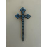 A crucifix pendant set with turquoise.