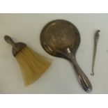 A silver backed hand mirror, a silver handled crumb brush and a silver handled button hook.