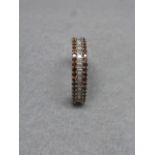 A 9ct white gold dress ring with a bagette diamond flanked by two rows of brown diamonds, size N/O.