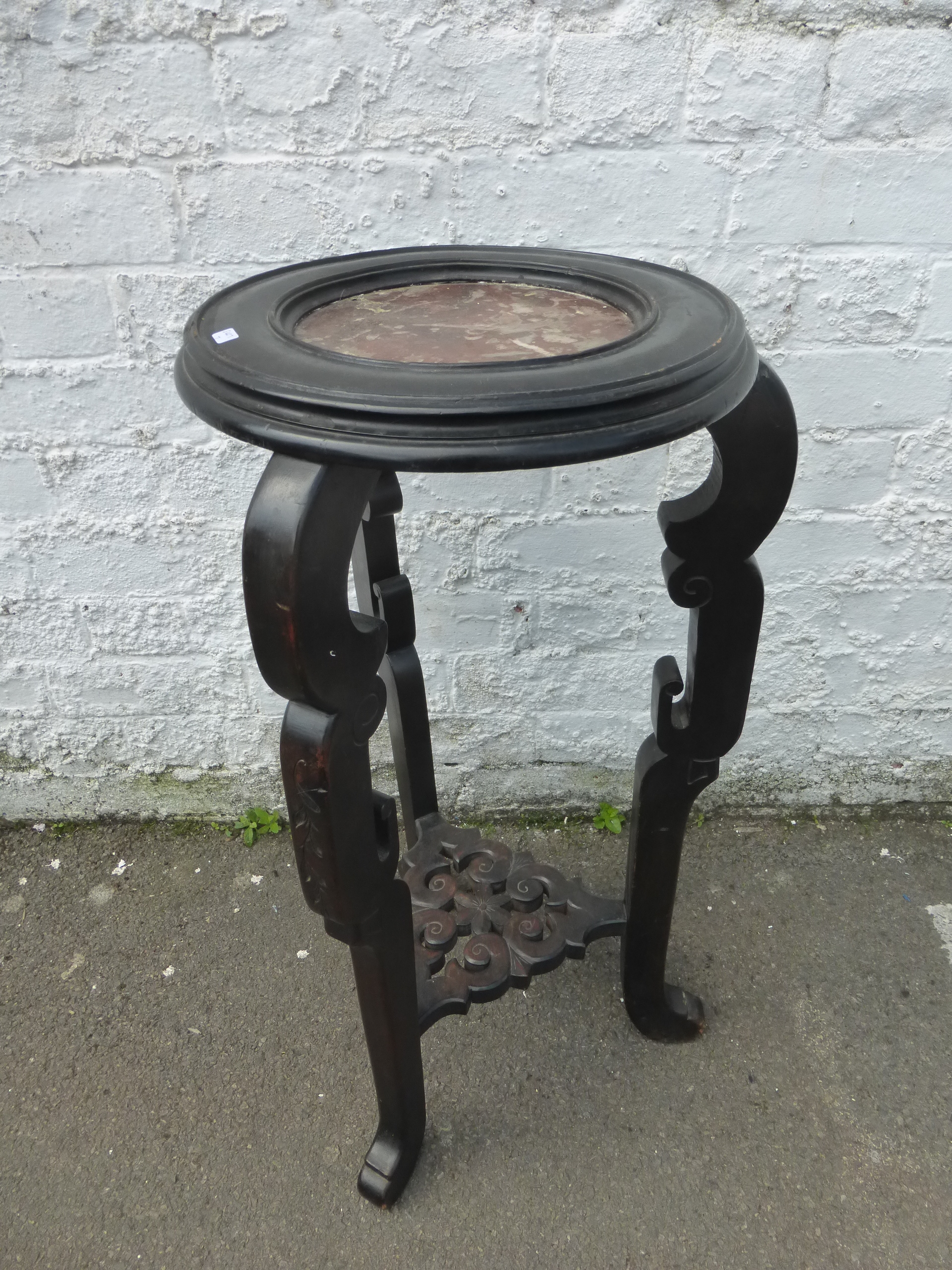 An ebonised and marble topped plant/lamp stand with pierced undertier.