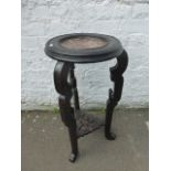 An ebonised and marble topped plant/lamp stand with pierced undertier.