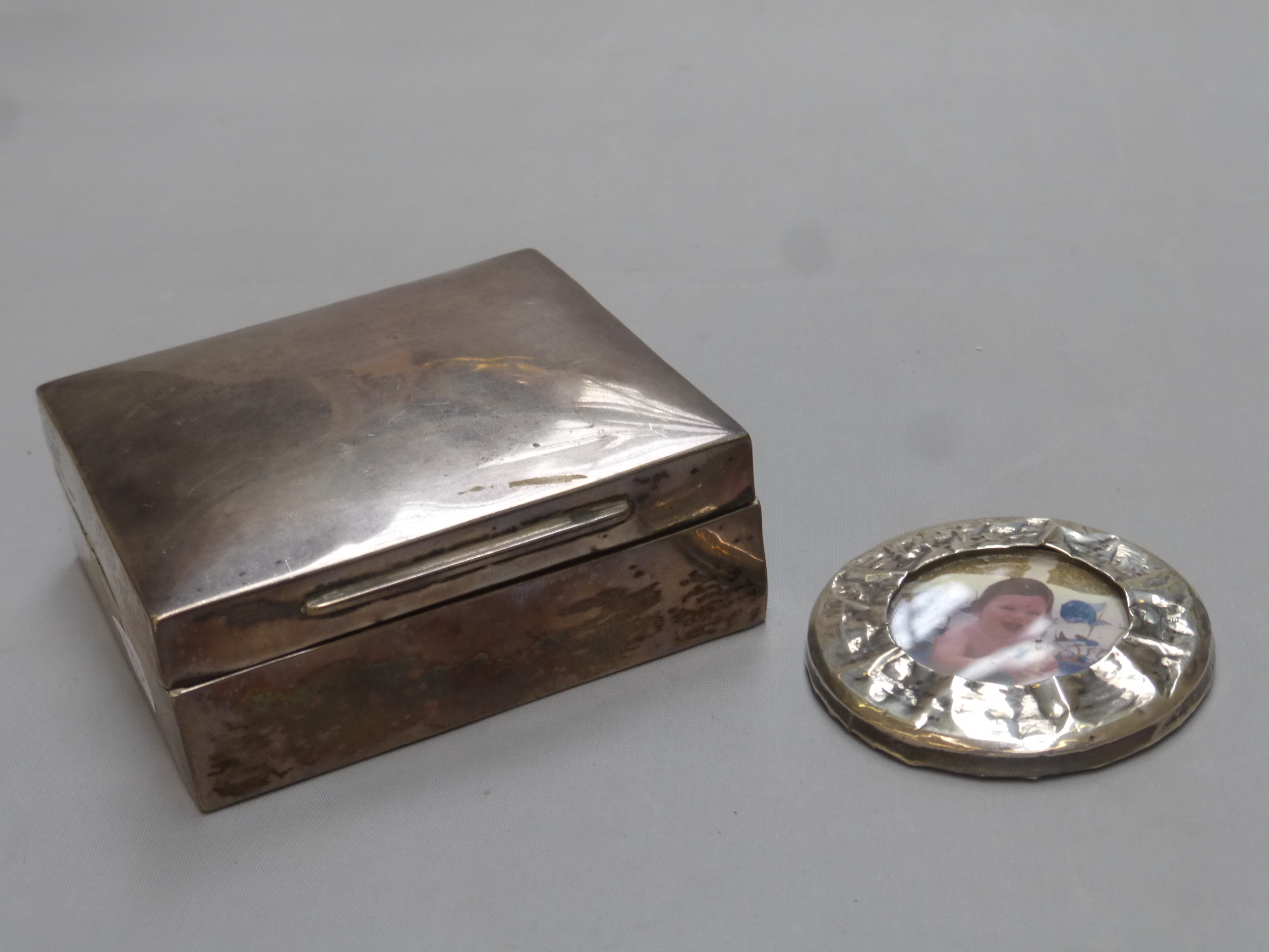 A silver cigarette box, maker - Kings and Sons, Chester, marks rubbed, and a circular silver