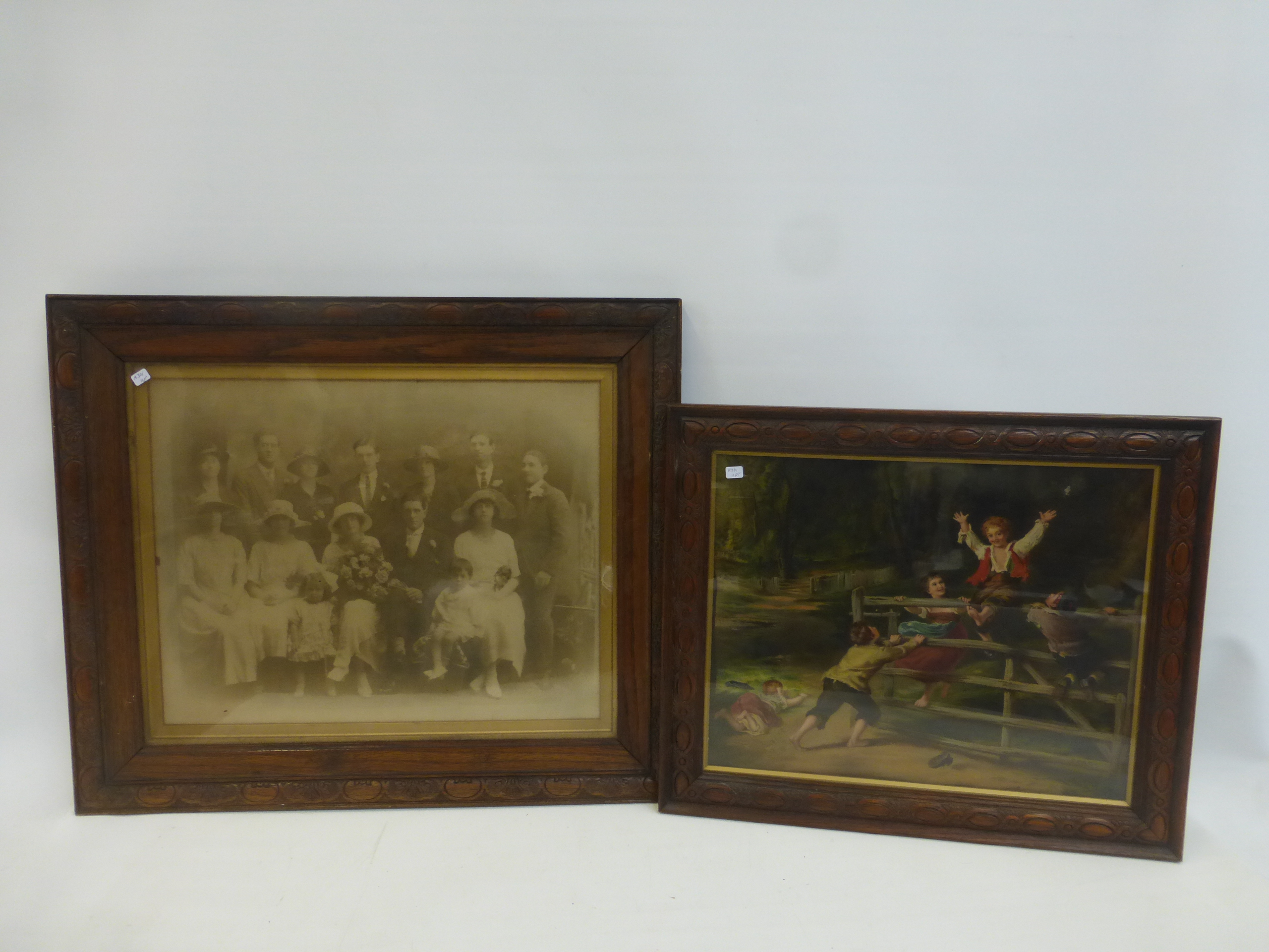 An oak framed Pears print and a similar oak picture frame surrounding a family wedding portrait.