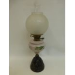 A Victorian oil lamp with painted opaline glass reservoir above a pierced metal base, with rounded