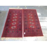 A pair of Keshan floor rugs with four central medallions on a red ground, both measuring 27 x 54" (