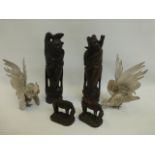 A pair of figures depicting fell ponies and a pair of carved wooden Oriental figures inlaid with