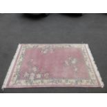 A room size handmade Chinese carpet with a pink ground and all round floral decoration, 72 x 108" (6