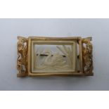 A decorative gilded rectangular brooch with a filigree mount, inset with pierced scene of a swan