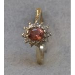 A 9ct gold ring set with a tourmaline surrounded by small diamonds.