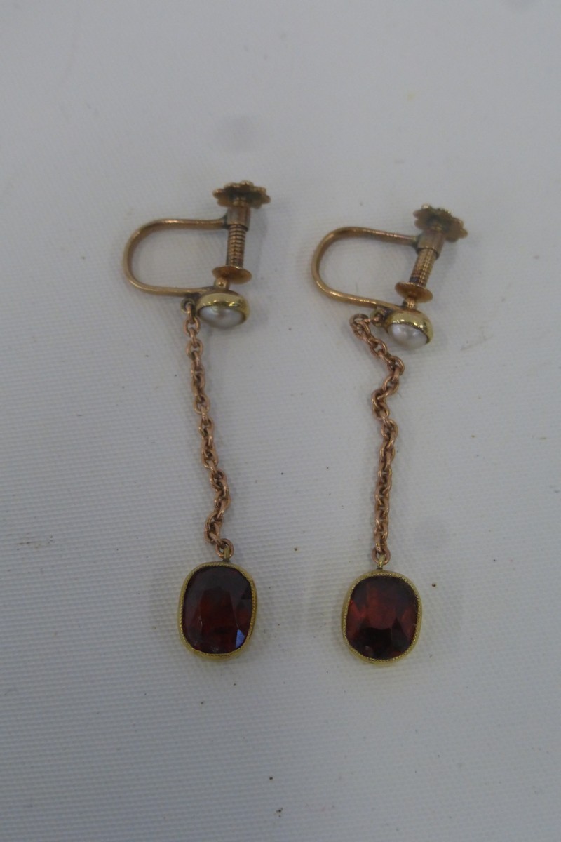 A pair of gold drop garnet earrings with screw clasps (unmarked).