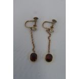 A pair of gold drop garnet earrings with screw clasps (unmarked).