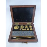 A set of brass apothecary weights and tweezers in a fitted mahogany case.