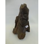 An African sculpture depicting a face with a branch/tree stump.