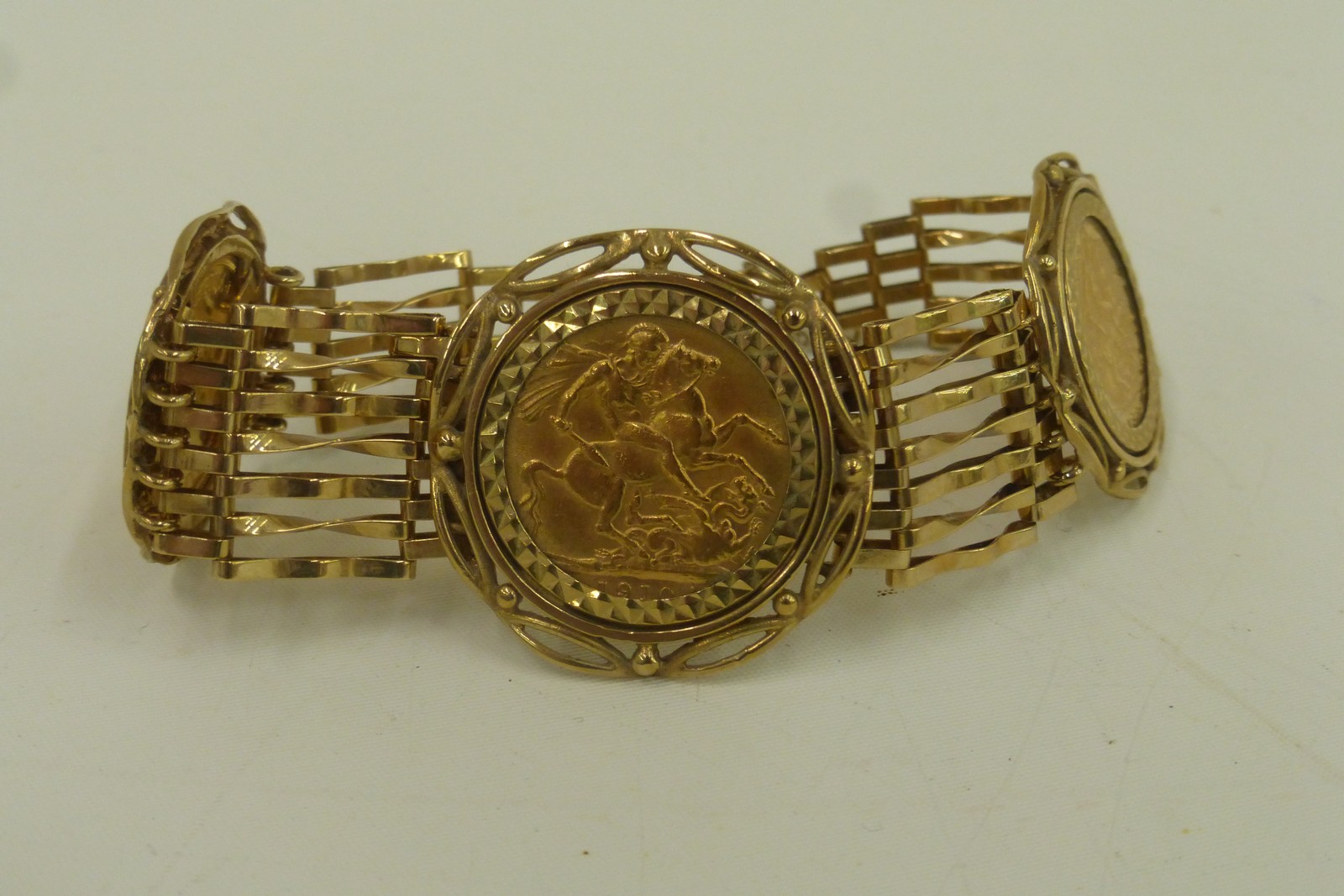 A 9ct gold bracelet set with two half sovereigns dated 1982 and a full sovereign dated 1910, total