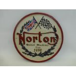 A circular cast metal Norton Motorcycle wall plaque.