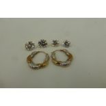 Three pairs of 9ct gold earrings including a pair of hooped and two pairs of CZ solitaire earrings.