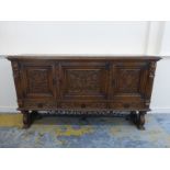 A large heavily carved oak serving sideboard with three cupboards above drawers.