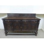A good quality oak sideboard with an inlaid and carved upstand, above two long frieze drawers and