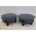 A pair of Victorian mahogany and upholstered circular footstools raised upon four part carved
