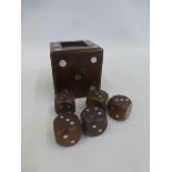 A wooden and metal inlaid lidded desk top dice box containing five wooden dice.