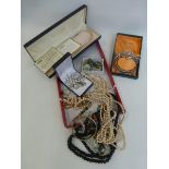 A box of assorted costume jewellery of various ages.