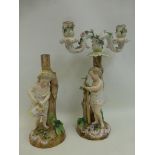 A pair of continental ceramic candle stands depicting a boy and girl watering plants and staking a