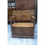 An early 20th Century oak monk's bench of good colour with geometric mouldings to the sliding top