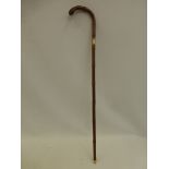 A cane walking stick with 18ct gold collar to the shaft.