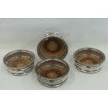 A set of four silver plated wine coasters.