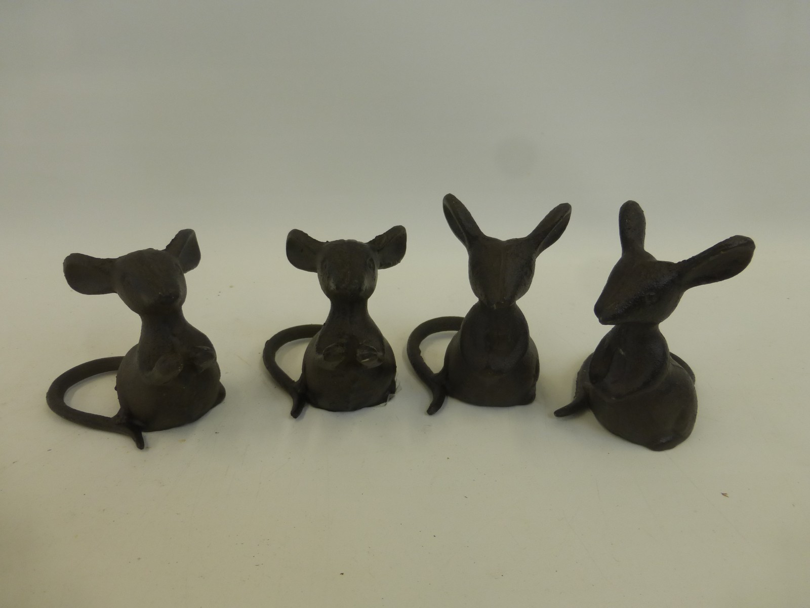 Four cast metal seated mice.