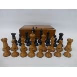 A cased set of ebonised and boxwood weighted chess pieces.